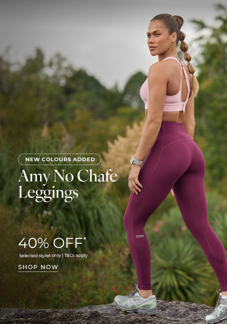 Woman standing on a rock in a natural outdoor setting, wearing a pink Lorna Jane sports bra and burgundy Amy No Chafe Leggings. Text: New Colours Added. Amy No Chafe Leggings 40% Off* Selected styles only | T&Cs apply - Shop Now