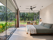 Large bed in a room with large glass walls. 