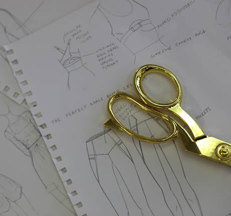 Gold Sewing Scissors sitting on top of papers on desk