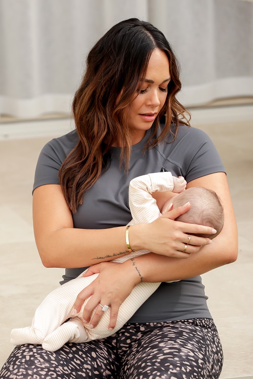 mother wearing a grey active feeding tee with zip for nursing while breast feeding a baby