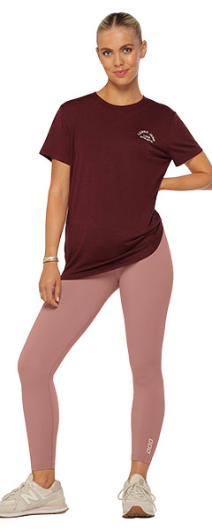 a woman wearing dusty pink leggings and a burgundy t-shirt
