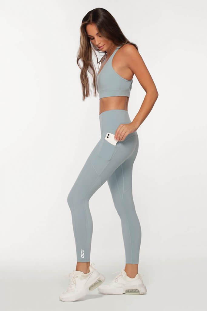 model wearing light blue everyday top with built in bra and matching light blue ankle biter leggings with phone pockets christmas gift for fitness lovers