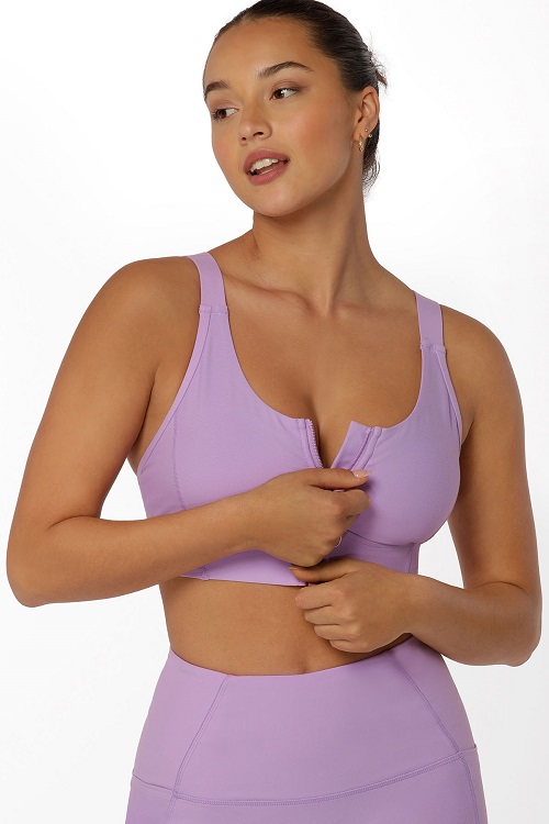 brunette woman wearing lilac purple zip front sports bra