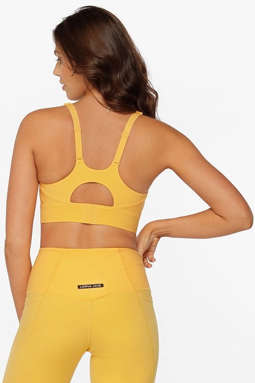 Model wearing bright yellow sports bra with thick straps for maximum support