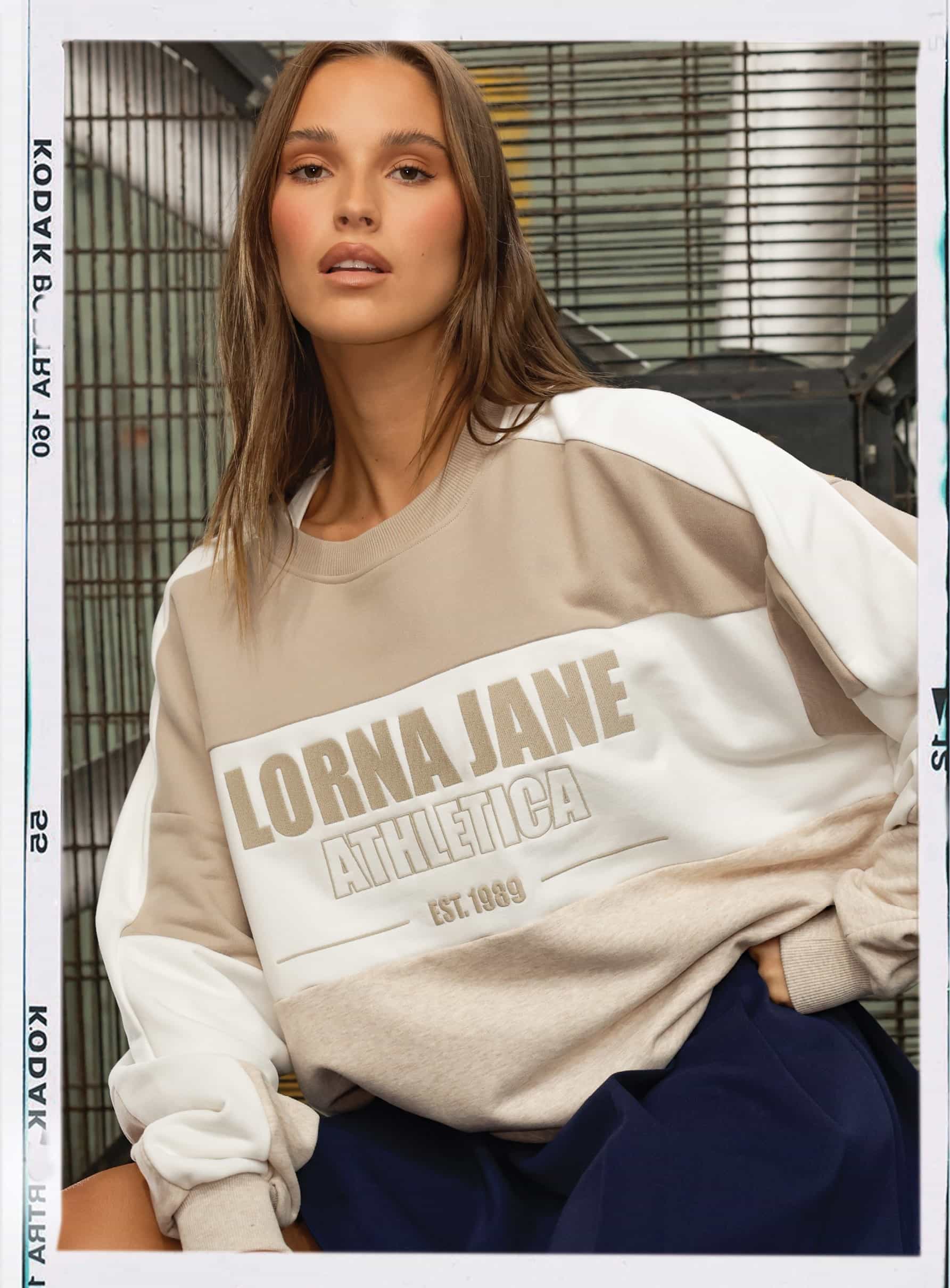 Front image of model wearing an oversized sweat with large Lorna Jane athletica branding
