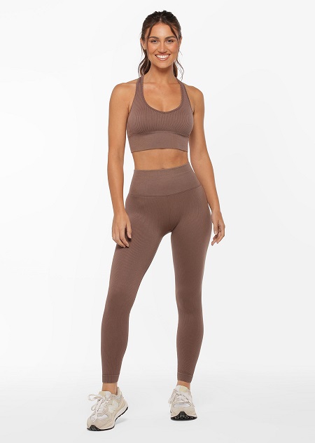 Model wearing a brown seamless sports bra and matching brown seamless ankle biter leggings