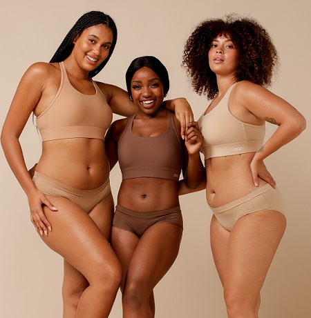 three women stagin together wearing lorna jane compress and compact high support bra in various shades