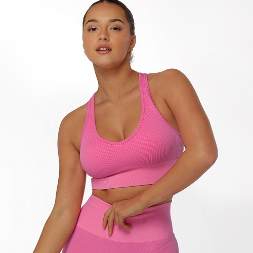 brunette woman wearing best medium impact sports bra pink ribbed seamless racerback sports bra